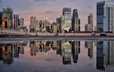 Reflection of buildings in city against sky