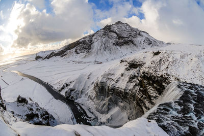 Scenic view of snowcapped mountain against cloudy sky