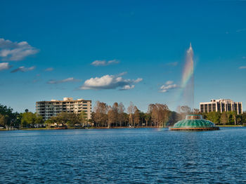 Rainbow over the fountain in the middle of the lake in the park. 