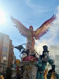 Low angle view of angel statue against sky