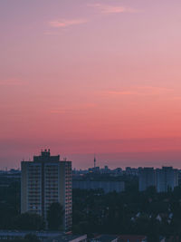 Exterior of buildings in city against sky during sunset