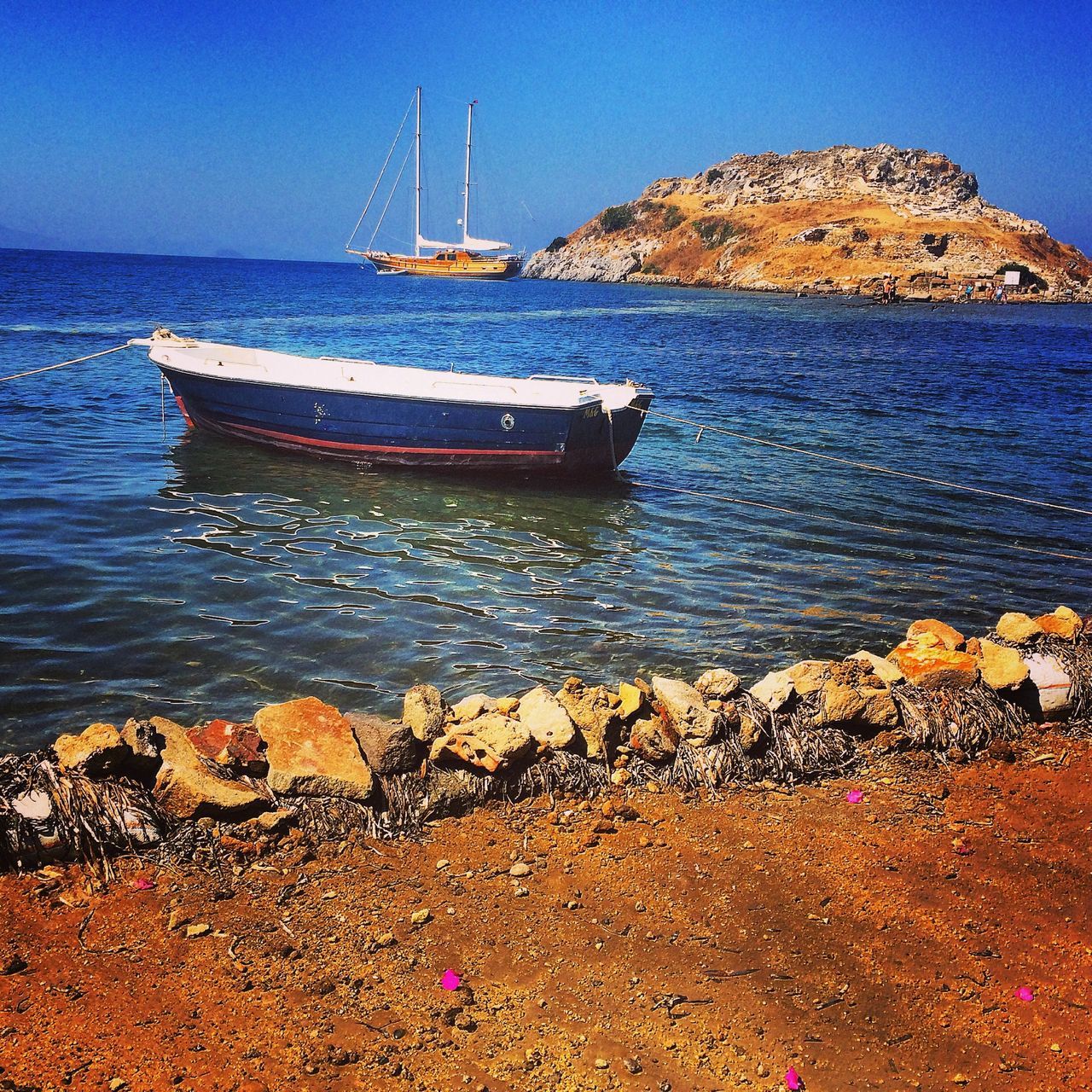 water, nautical vessel, transportation, boat, sea, mode of transport, moored, tranquility, blue, tranquil scene, scenics, beauty in nature, clear sky, nature, sky, beach, shore, rock - object, day, rippled