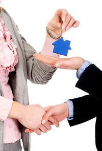 Midsection of couple holding hands over white background