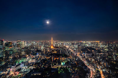 Illuminated cityscape against sky at night