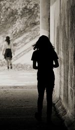 Rear view of silhouette woman walking on road