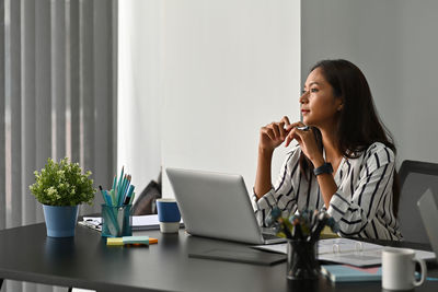 Young woman drinking coffee at table