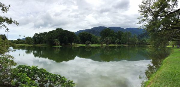 Scenic view of lake by trees against sky