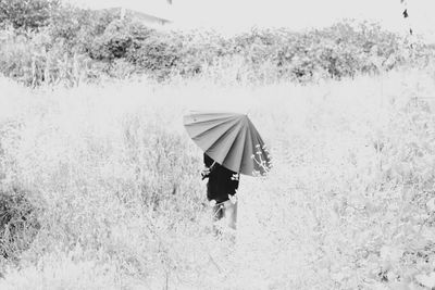 Rear view of woman walking on field
