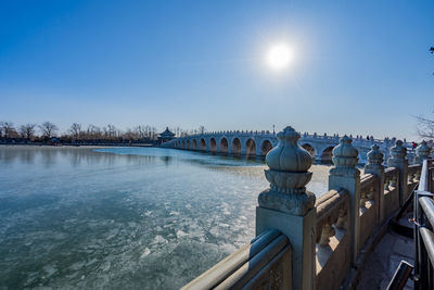 Bridge over river against sky during winter