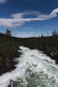 Scenic view of waterfall against sky