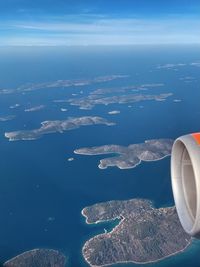 Aerial view of sea and airplane flying in sky