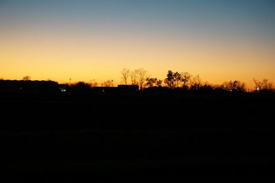 Silhouette landscape against clear sky during sunset