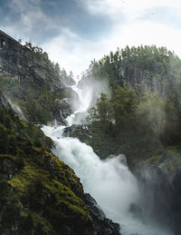 Scenic view of waterfall against sky