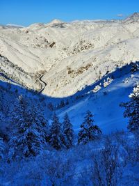 Scenic view of snowcapped mountains against blue sky