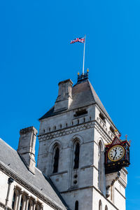 Low angle view of clock tower against clear blue sky