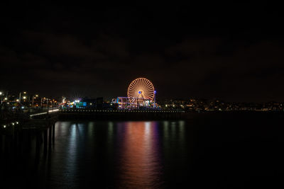 Illuminated ferris wheel in city at night