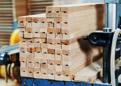 Stack of wooden bars in carpentry workshop. woodworking industry.