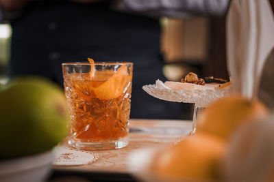 Midsection of woman holding drink on table