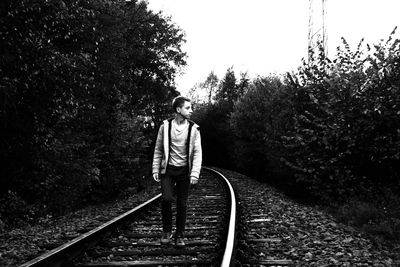 Rear view of woman walking on railroad track