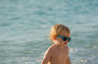 Portrait of shirtless boy standing in sea