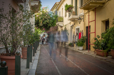 People walking on street amidst buildings in city