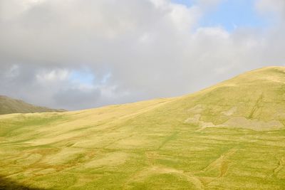 Countryside landscape against cloudy sky