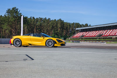 Yellow car on road against sky