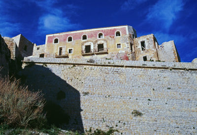 Low angle view of old building against cloudy sky