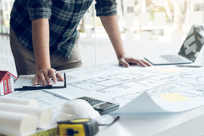 Midsection of man working on table