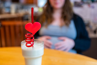 Midsection of woman holding ice cream in cafe