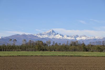 Scenic view of field and mountains against sky