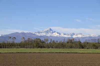 Scenic view of field and mountains against sky