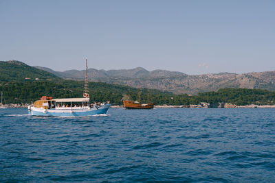 Boat sailing in sea against clear sky