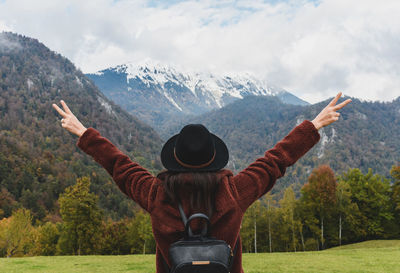 Rear view of person standing on landscape against mountain range