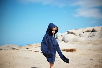 Man standing on beach against blue sky