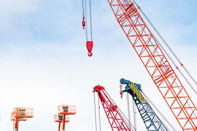 Low angle view of crane at construction site against sky