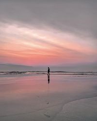 Lady admiring the sunrise on the beach
