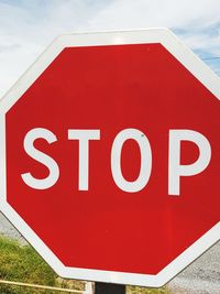 Close-up of road sign against sky