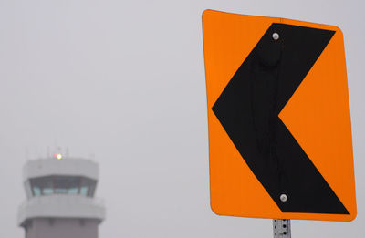 Low angle view of road sign against clear sky