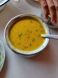 Close-up of hand holding bowl of soup