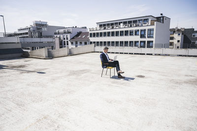 Businessman using laptop on sunny day