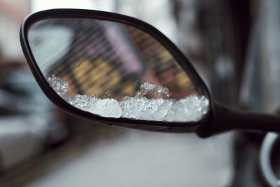 Close-up of wet side-view mirror