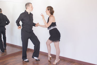 Full length of couple dancing at studio