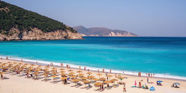 Panoramic view of people on beach against sky