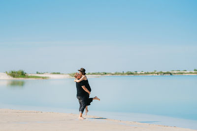 Full length of man standing on beach against sky