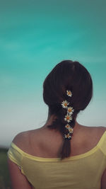 Rear view of woman with black hair against white background