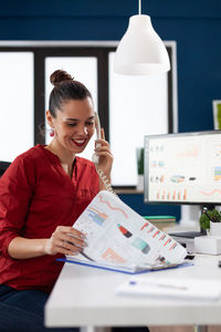 Businesswoman talking on phone in office