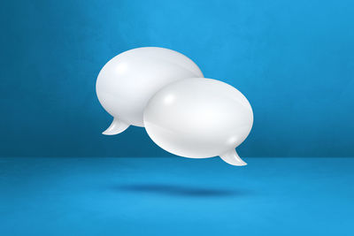 Close-up of white balloon against blue background