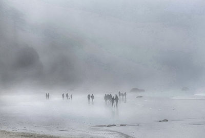 People walking on snow covered landscape