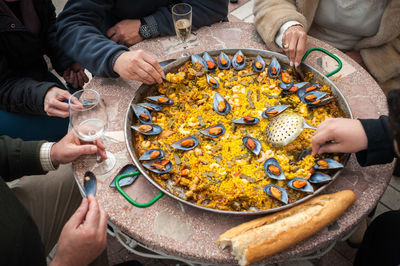 Mid section of people sitting at table with oysters in plate